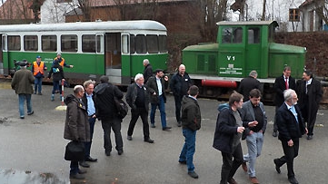 Fahrgäste vor Lok und Personenwagen auf dem Weg zum Mittagessen
